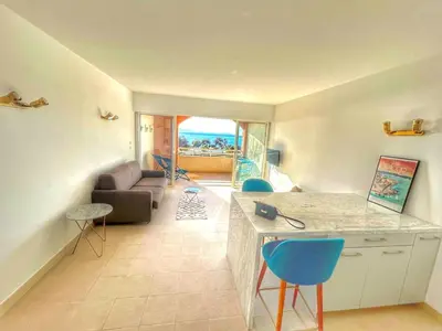 a living room with a couch and a table and chairs at Studio Cosy à 50m de la plage avec Parking - Résidence ARIA MARINA route des sanguinaires in Ajaccio