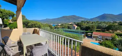 a balcony with a table and chairs and mountains at T2 Résidence Dolce & Vita C5 vue mer et piscine in Propriano