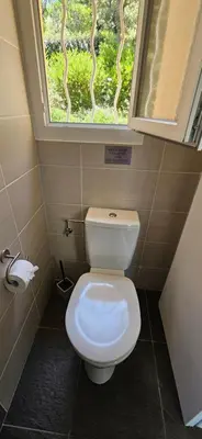 a bathroom with a toilet with a window at T2 Résidence Dolce & Vita C5 vue mer et piscine in Propriano