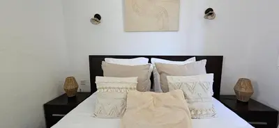 a bed with white sheets and pillows on it at T2 Résidence Dolce & Vita C5 vue mer et piscine in Propriano