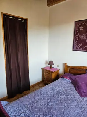a bedroom with a bed and a table with a lamp at Ferme Auberge U Cantu d'Adelio in Olivese