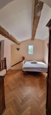 a bedroom with a bed in a room with wooden floors at Maison accès direct plage corse du sud in Coti-Chiavari