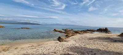 a sandy beach with rocks in the water at Maison accès direct plage corse du sud in Coti-Chiavari