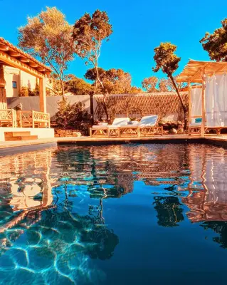 a swimming pool with two chairs and a house at bergerie-ucaseddu in Zonza