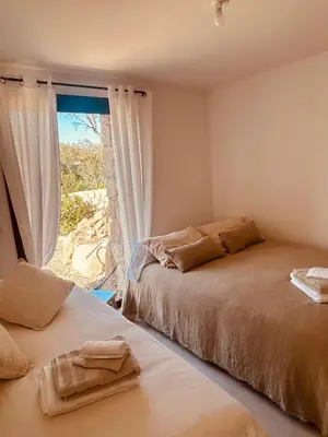 a bedroom with two beds and a window at bergerie-ucaseddu in Zonza