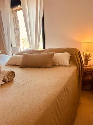 a bedroom with a large bed with a window at bergerie-ucaseddu in Zonza