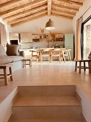 a large living room with a table and a kitchen at bergerie-ucaseddu in Zonza