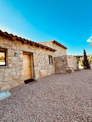 a stone house with a garage in a gravel driveway at bergerie-ucaseddu in Zonza