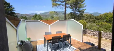 a room with a table and chairs on a deck at Appartement Lelia in Sotta