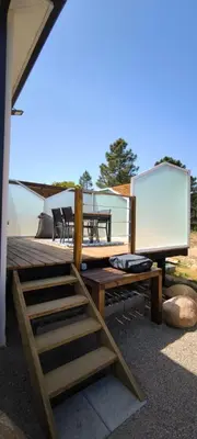 a wooden deck with benches and a white screen at Appartement Lelia in Sotta