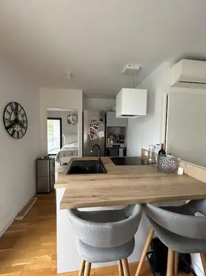 a kitchen with a wooden table and two chairs at Appartement T2 très bon standing ! in Ajaccio