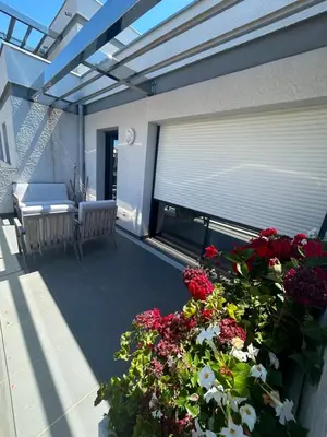 a balcony with flowers and a window with a blind at Appartement T2 très bon standing ! in Ajaccio