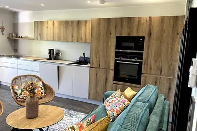 a living room with a blue couch and a kitchen at Appartement T2 Vue Mer Porticcio in Porticcio
