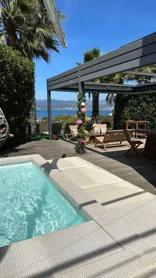 a swimming pool in a backyard with a pergola at Appartement T2 Vue Mer Porticcio in Porticcio