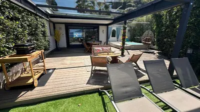 a wooden deck with chairs and a grill at Appartement T2 Vue Mer Porticcio in Porticcio