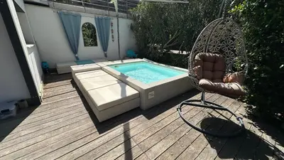 a swimming pool with a chair on a wooden deck at Appartement T2 Vue Mer Porticcio in Porticcio