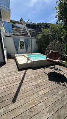 a deck with a chair and a swimming pool at Appartement T2 Vue Mer Porticcio in Porticcio