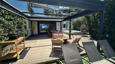 a wooden deck with chairs and a table and a grill at Appartement T2 Vue Mer Porticcio in Porticcio