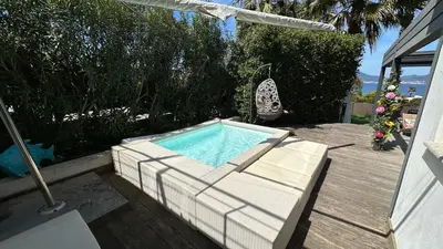 a swimming pool sitting on a deck next to a house at Appartement T2 Vue Mer Porticcio in Porticcio