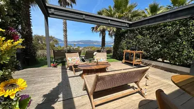 a patio with chairs and a table on a deck at Appartement T2 Vue Mer Porticcio in Porticcio