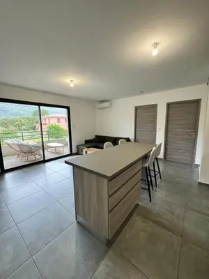 a kitchen with a island in a living room at Logement calme et agréable in Borgo