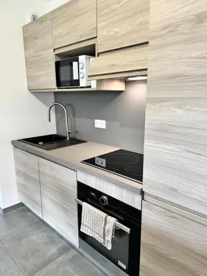 a kitchen with a sink and a stove top oven at Logement calme et agréable in Borgo