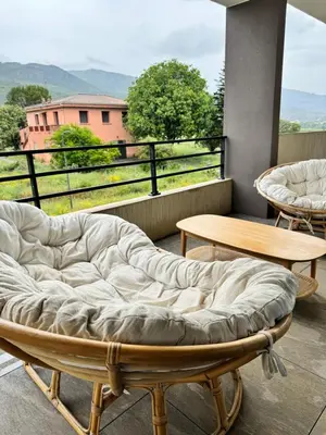 a bed sitting on top of a balcony with a table at Logement calme et agréable in Borgo