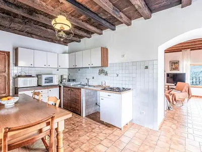 a kitchen with a table and a dining room at Holiday Home Piana by Interhome in San-Giovanni-di-Moriani