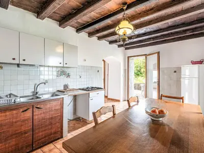 a kitchen with a wooden table and a wooden ceiling at Holiday Home Piana by Interhome in San-Giovanni-di-Moriani