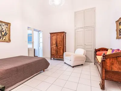 a bedroom with a bed and a dresser and a chair at Apartment Casa Grandval by Interhome in Ajaccio