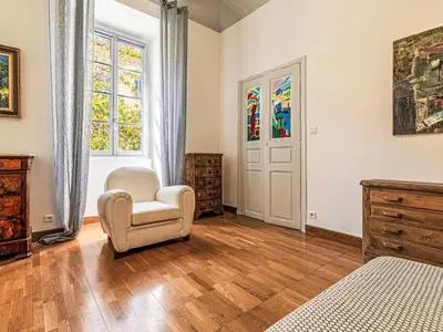a bedroom with a white chair and a window at Apartment Casa Grandval by Interhome in Ajaccio