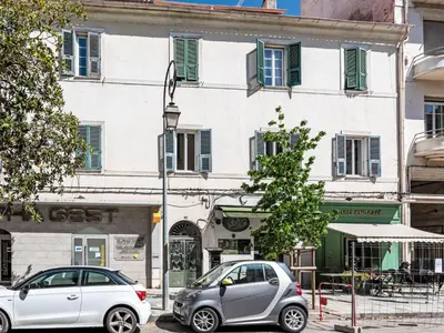 two cars parked in front of a white building at Apartment Casa Grandval by Interhome in Ajaccio