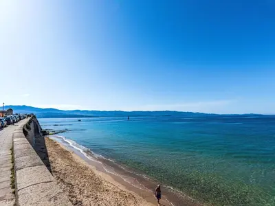 a person walking on a beach next to the ocean at Apartment Casa Grandval by Interhome in Ajaccio