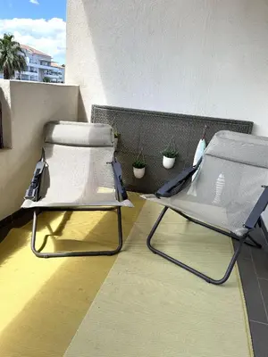 two lounge chairs sitting on a balcony with plants at MORIANI Plage T2 terrasse proche mer et commerces in Moriani Plage
