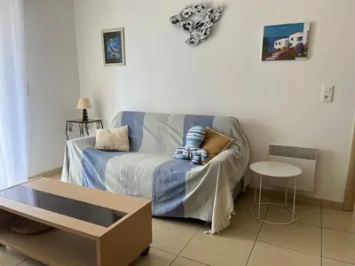 a living room with a couch and a table at MORIANI Plage T2 terrasse proche mer et commerces in Moriani Plage