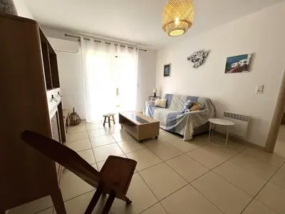 a living room with a couch and a table at MORIANI Plage T2 terrasse proche mer et commerces in Moriani Plage