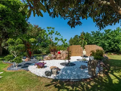 a fountain in a garden with rocks and trees at Holiday Home Campestra by Interhome in Coti-Chiavari