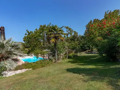 a swimming pool in a yard with trees and a field at Holiday Home Campestra by Interhome in Coti-Chiavari