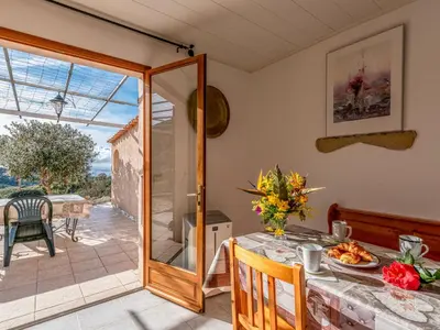 a dining room with a table and a glass door at Holiday Home Campestra by Interhome in Coti-Chiavari
