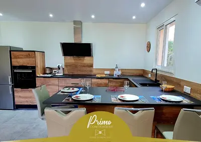 a kitchen with a table and chairs in a kitchen at Havre de paix, 5 min de la mer in Zonza