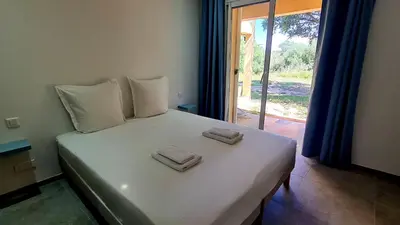 a bedroom with a white bed with two towels on it at Havre de paix, 5 min de la mer in Zonza