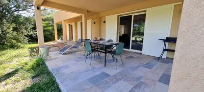 a patio with a table and chairs on a house at Havre de paix, 5 min de la mer in Zonza