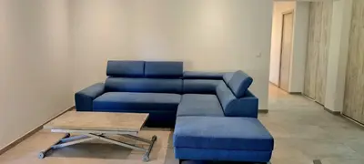 a living room with a blue couch and a coffee table at Havre de paix, 5 min de la mer in Zonza
