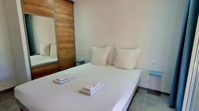 a bedroom with a white bed with two towels on it at Havre de paix, 5 min de la mer in Zonza
