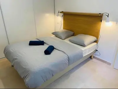 a bed with two pillows on it in a room at T2 neuf vue mer, piscine chauffée N194 in Linguizzetta
