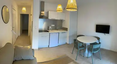 a kitchen and a living room with a table and chairs at T2 neuf vue mer, piscine chauffée N194 in Linguizzetta