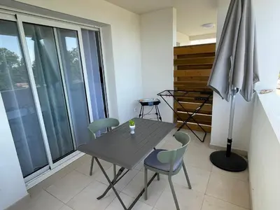 a dining room with a table and chairs and a window at T2 neuf vue mer, piscine chauffée N194 in Linguizzetta