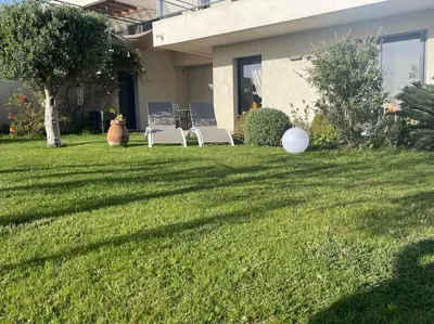two lawn chairs sitting in the yard of a house at Rez de villa Machja vue mer et montagne à 2mn port in Sari Solenzara