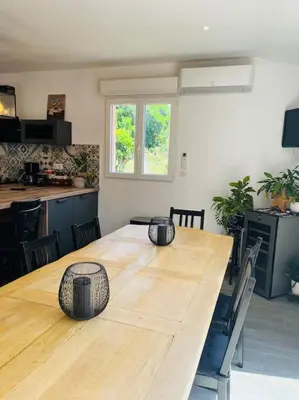 a large wooden table in a room with a kitchen at Charmante Villa avec Piscine in Appietto