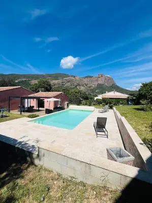 a swimming pool with a chair next to a house at Charmante Villa avec Piscine in Appietto